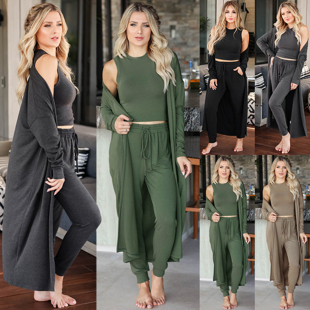 This three-piece set for women features a knitted cardigan with a sleeveless shirt and long pants. A sophisticated and comfortable sports suit ensemble.